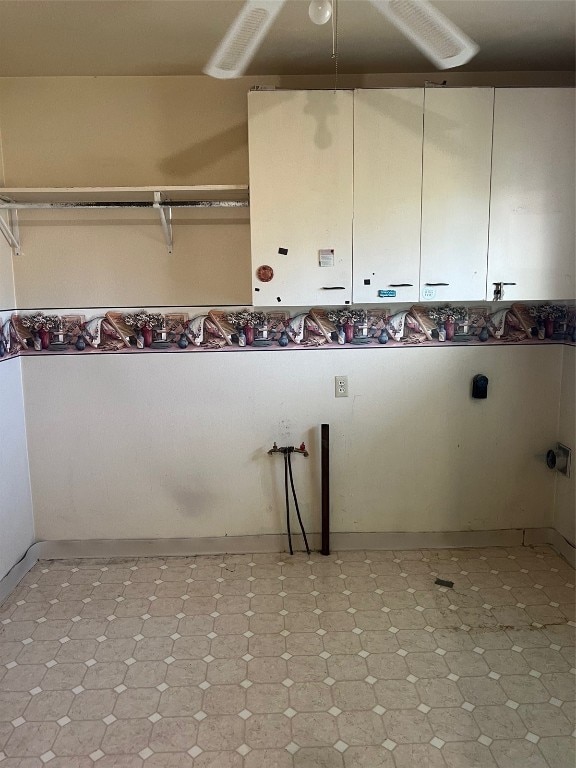 washroom featuring ceiling fan and cabinets