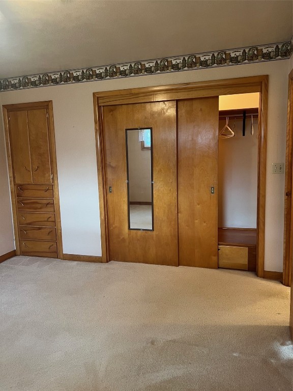 unfurnished bedroom with a closet and carpet flooring