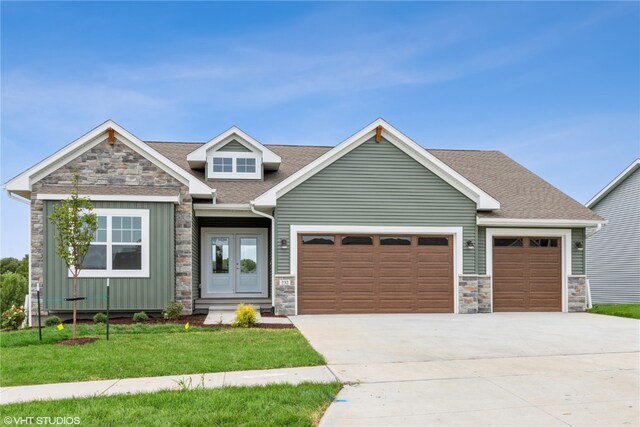 craftsman house with a front lawn and a garage