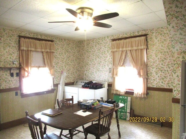 dining space featuring a healthy amount of sunlight, a drop ceiling, ceiling fan, and independent washer and dryer