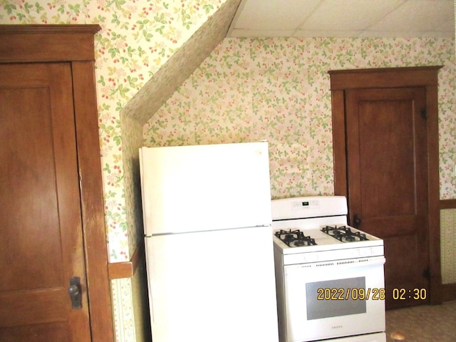 kitchen with white appliances and a paneled ceiling