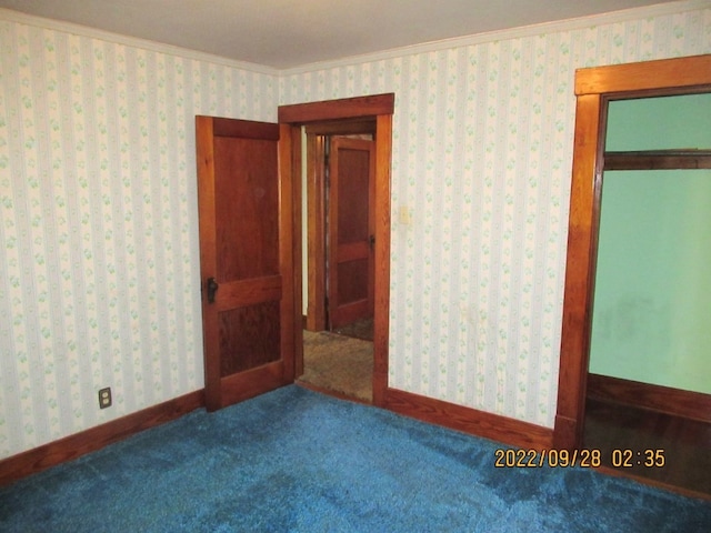 spare room featuring ornamental molding and carpet flooring