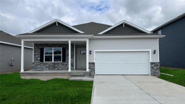 view of front of property featuring a porch, a garage, and a front lawn