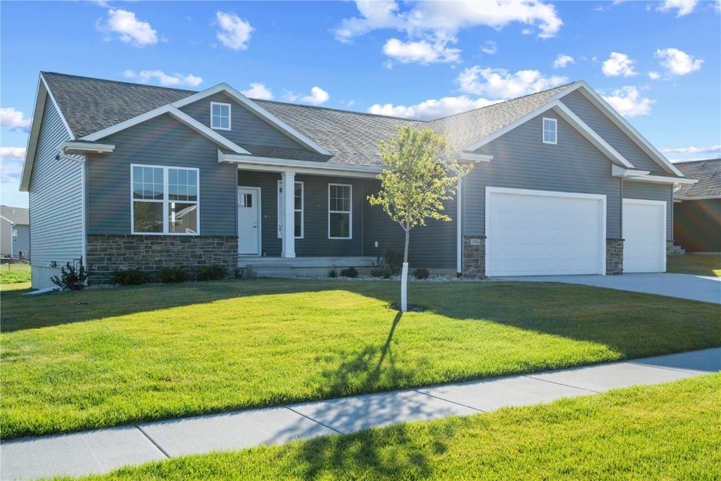 craftsman-style house with a garage and a front lawn