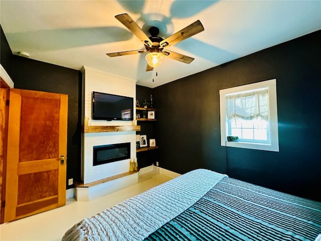 bedroom with a large fireplace and ceiling fan