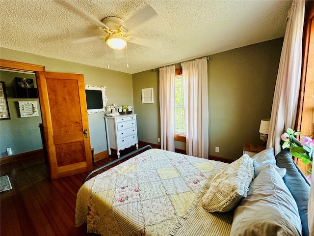 bedroom with ceiling fan, a textured ceiling, and dark hardwood / wood-style floors