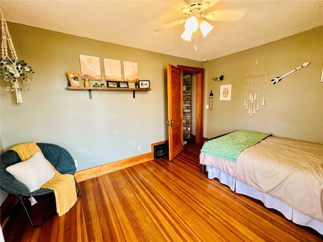 bedroom featuring a textured ceiling, hardwood / wood-style flooring, and ceiling fan