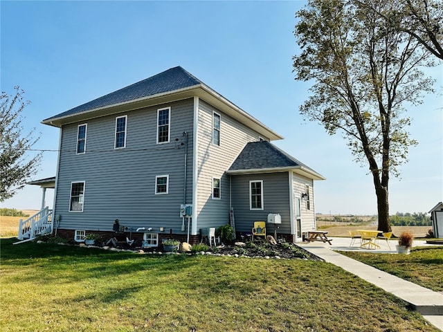 rear view of property featuring a patio and a lawn