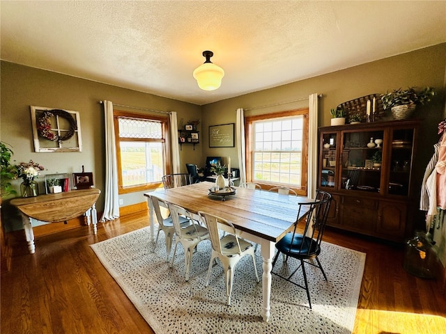 dining room with dark hardwood / wood-style floors and a textured ceiling