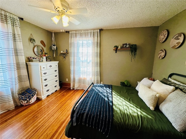 bedroom featuring ceiling fan, a textured ceiling, and hardwood / wood-style floors