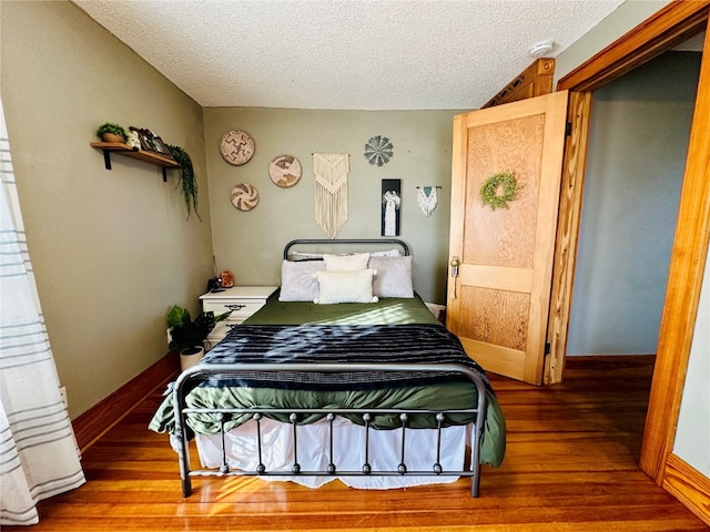 bedroom featuring hardwood / wood-style floors and a textured ceiling