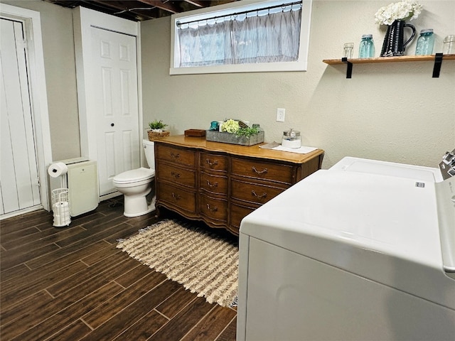 laundry area with dark wood-type flooring and washer and dryer