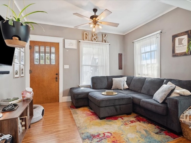 living room with light hardwood / wood-style floors, crown molding, and ceiling fan