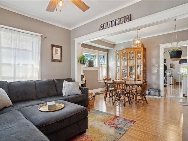 living room featuring ornamental molding, wood-type flooring, and ceiling fan