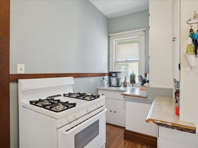 kitchen with white range with gas cooktop, dark hardwood / wood-style floors, and white cabinets