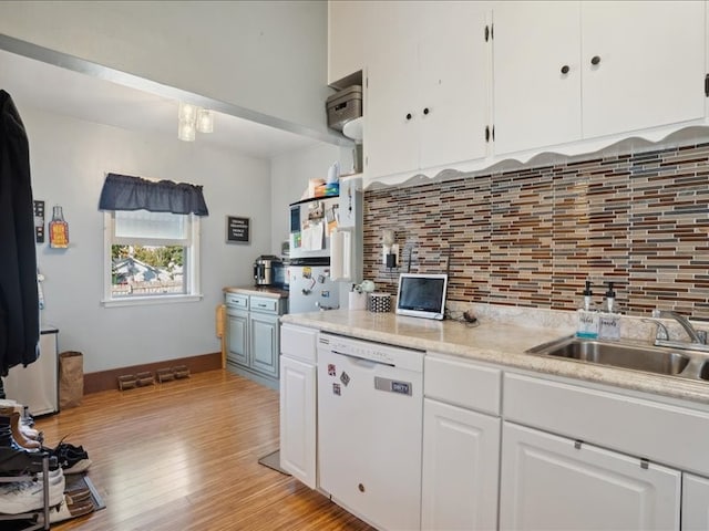 kitchen with sink, light wood-type flooring, white dishwasher, white cabinetry, and decorative backsplash