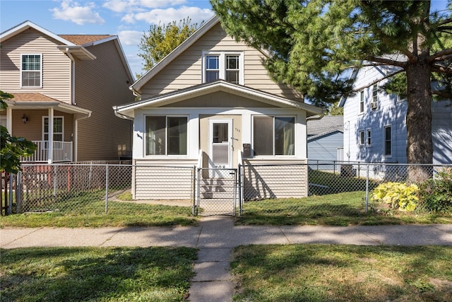 bungalow-style house featuring a sunroom and a front lawn