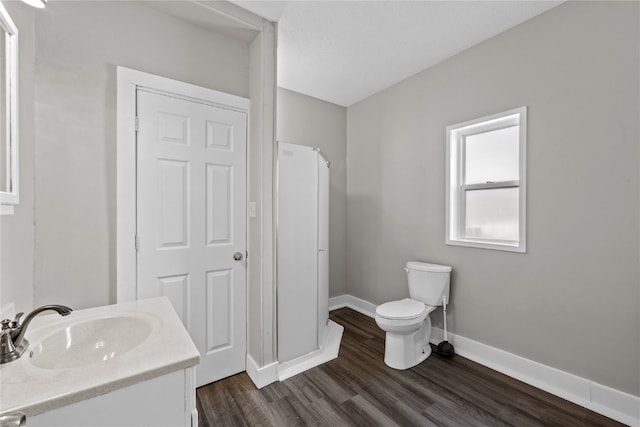 bathroom featuring hardwood / wood-style floors, a textured ceiling, vanity, and toilet