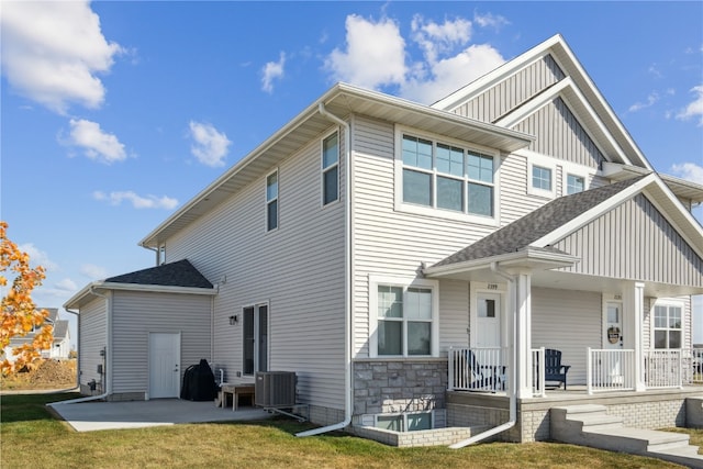 rear view of property featuring a porch and central air condition unit