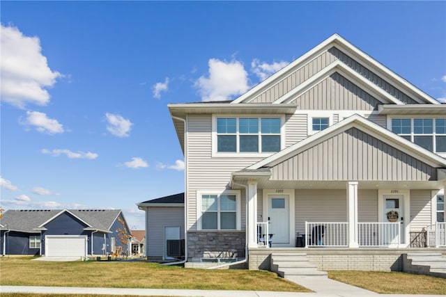 craftsman inspired home featuring a garage, a porch, and a front lawn