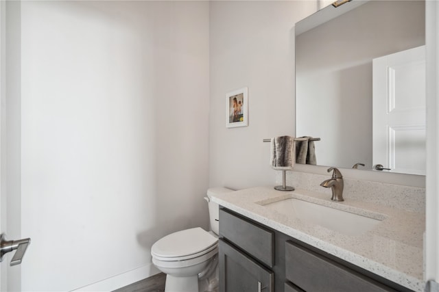 bathroom featuring wood-type flooring, vanity, and toilet