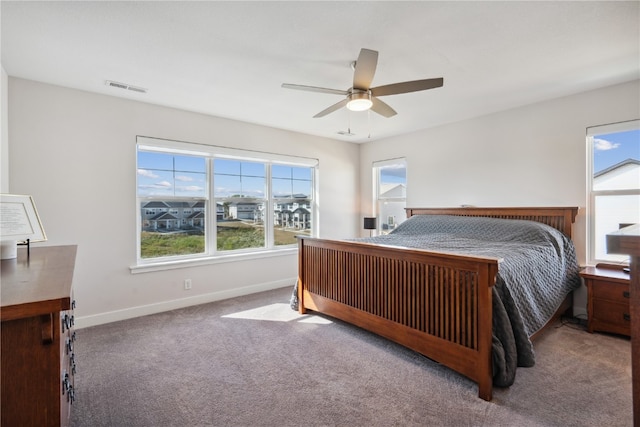 carpeted bedroom with multiple windows and ceiling fan