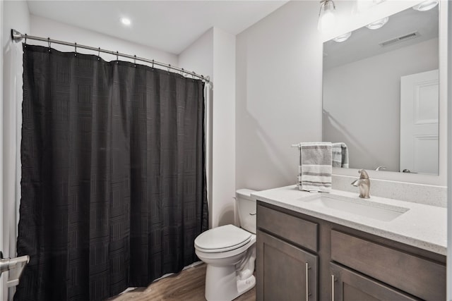 bathroom with a shower with curtain, vanity, toilet, and hardwood / wood-style flooring