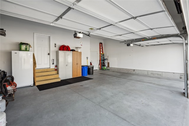 garage with a garage door opener and white fridge