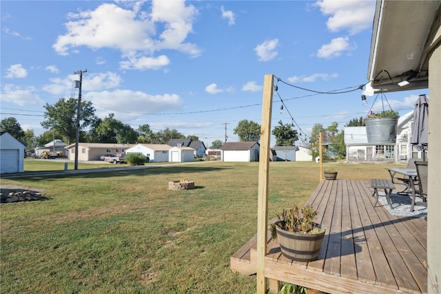 view of yard featuring a fire pit, a deck, and an outbuilding