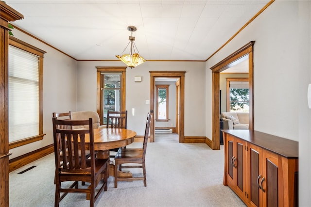 carpeted dining area with a healthy amount of sunlight, crown molding, and a chandelier