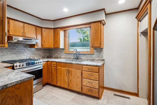 kitchen featuring backsplash, light tile patterned floors, stainless steel range with gas cooktop, crown molding, and sink