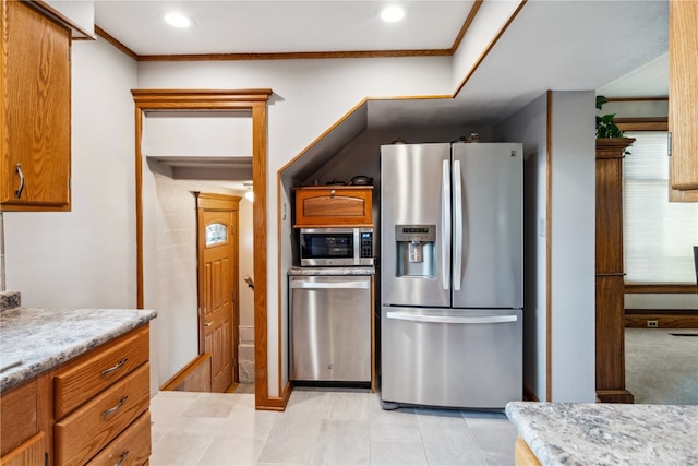 kitchen featuring light tile patterned floors, stainless steel appliances, and ornamental molding