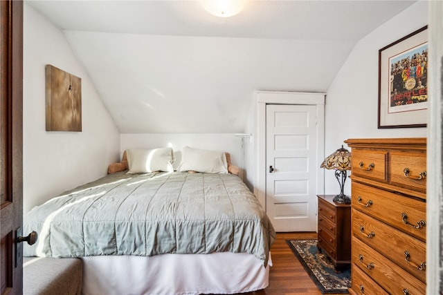 bedroom with vaulted ceiling and dark wood-type flooring