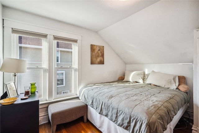 bedroom with wood-type flooring, lofted ceiling, and multiple windows