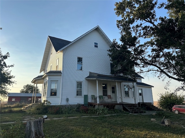 view of front of property with a porch and a yard