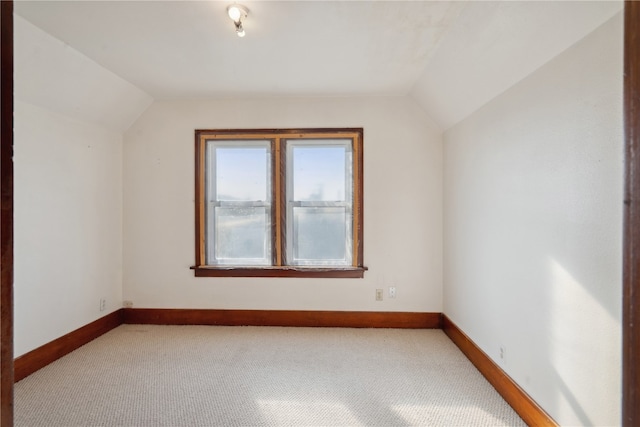 additional living space with vaulted ceiling and light carpet