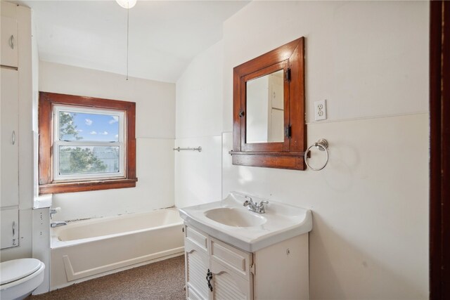 bathroom featuring a bathing tub, vanity, and toilet