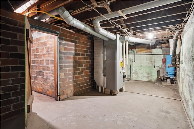 basement with heating unit and brick wall