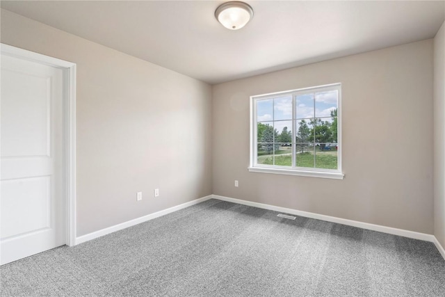 carpeted empty room with visible vents and baseboards