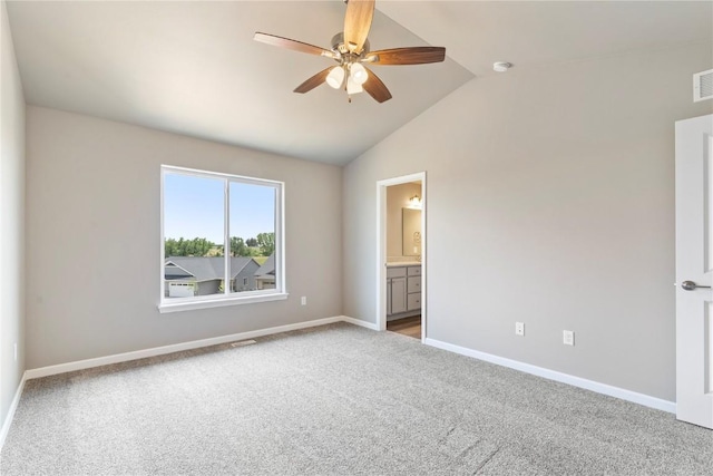 unfurnished bedroom featuring carpet flooring, visible vents, baseboards, vaulted ceiling, and ensuite bath