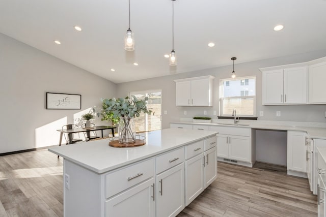 kitchen featuring a healthy amount of sunlight, light hardwood / wood-style floors, and sink