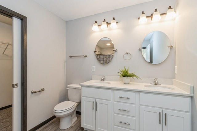 bathroom featuring wood-type flooring, vanity, and toilet