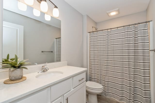 bathroom with a shower with curtain, vanity, and toilet