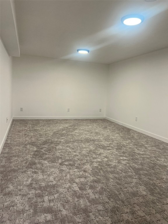 unfurnished room featuring dark carpet