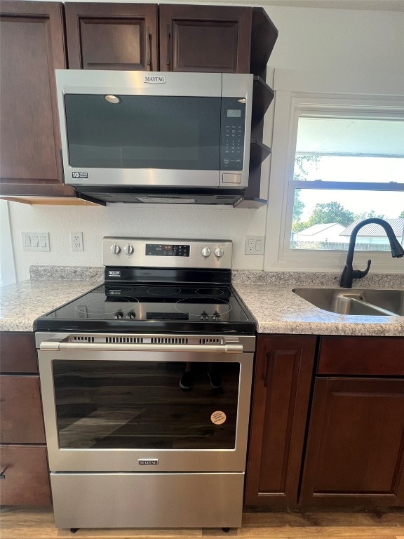 kitchen featuring dark brown cabinetry, stainless steel appliances, and sink