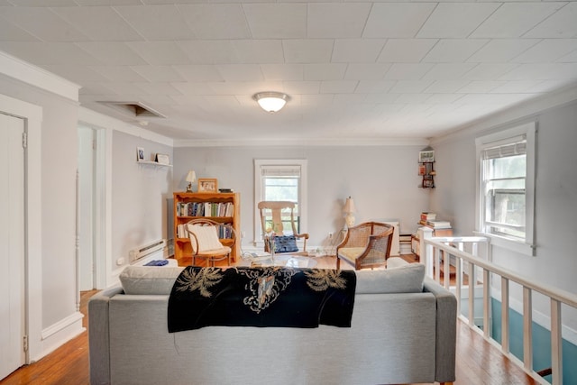 living room with baseboard heating, crown molding, and hardwood / wood-style floors