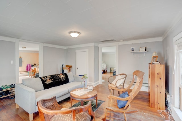 living room featuring wood-type flooring, baseboard heating, and plenty of natural light