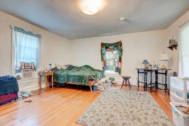 bedroom with cooling unit and hardwood / wood-style flooring