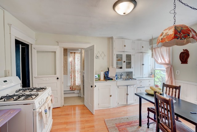 kitchen featuring white cabinetry, light hardwood / wood-style floors, a baseboard heating unit, and white range with gas cooktop