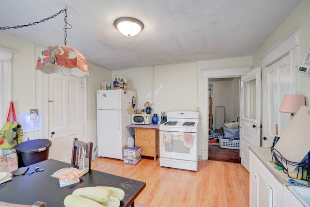 kitchen featuring white appliances, light hardwood / wood-style floors, and white cabinetry